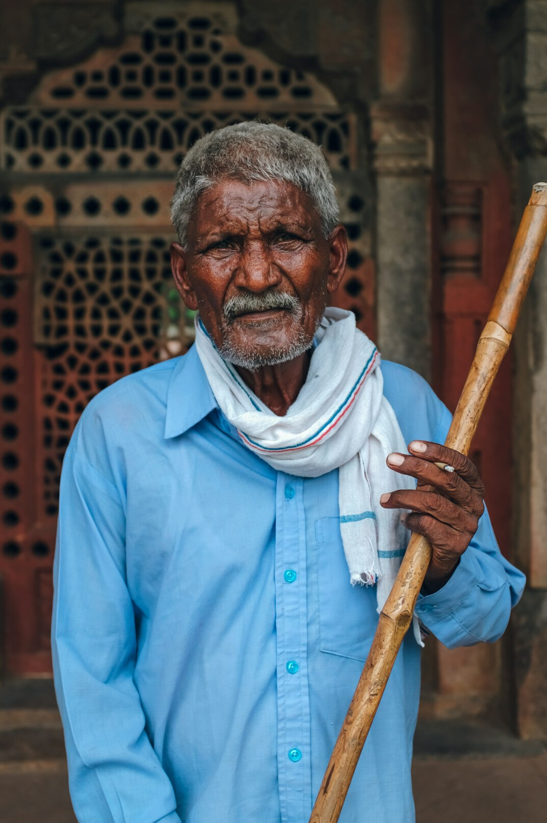 Portrait of a friendly senior man with white hair in a blue shirt