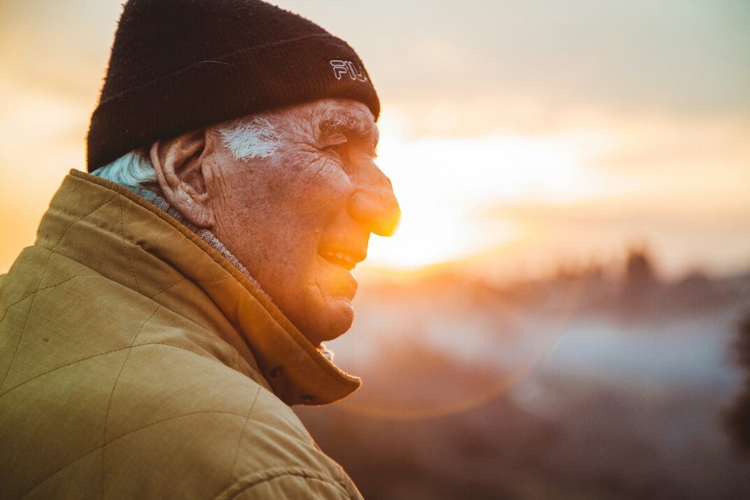 Portrait of a senior man with a flat cap smiling outdoors